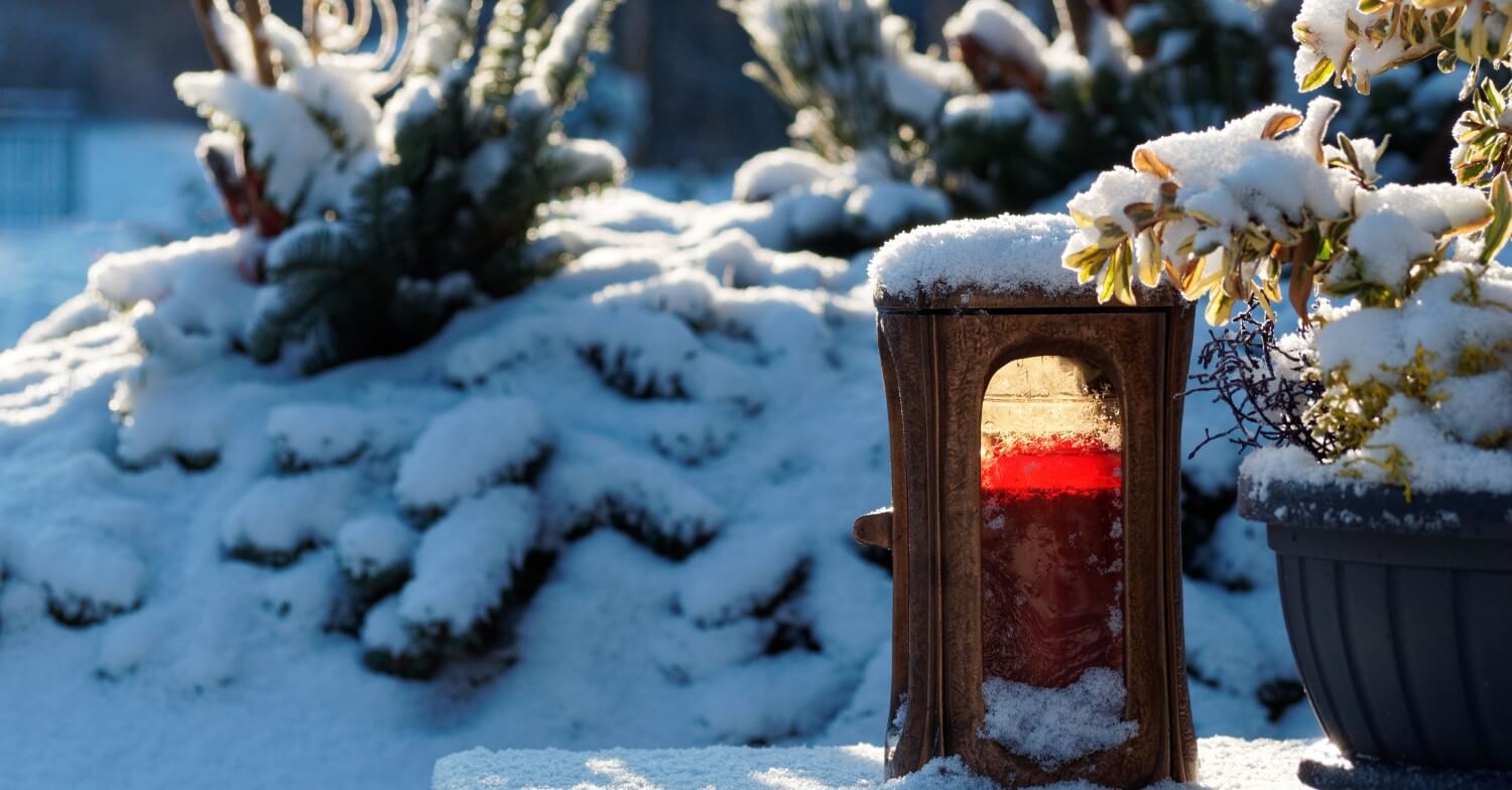 Ewiges Licht auf dem Friedhof ist von Schnee bedeckt