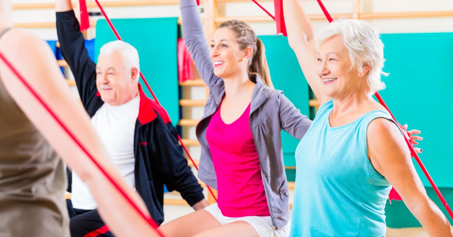 Eine Gruppe Senioren trainiert mit Fitnessbändern